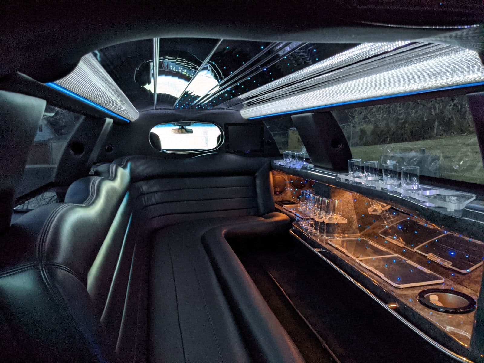 Illuminated black stretch limousine interior with bar and mood lighting